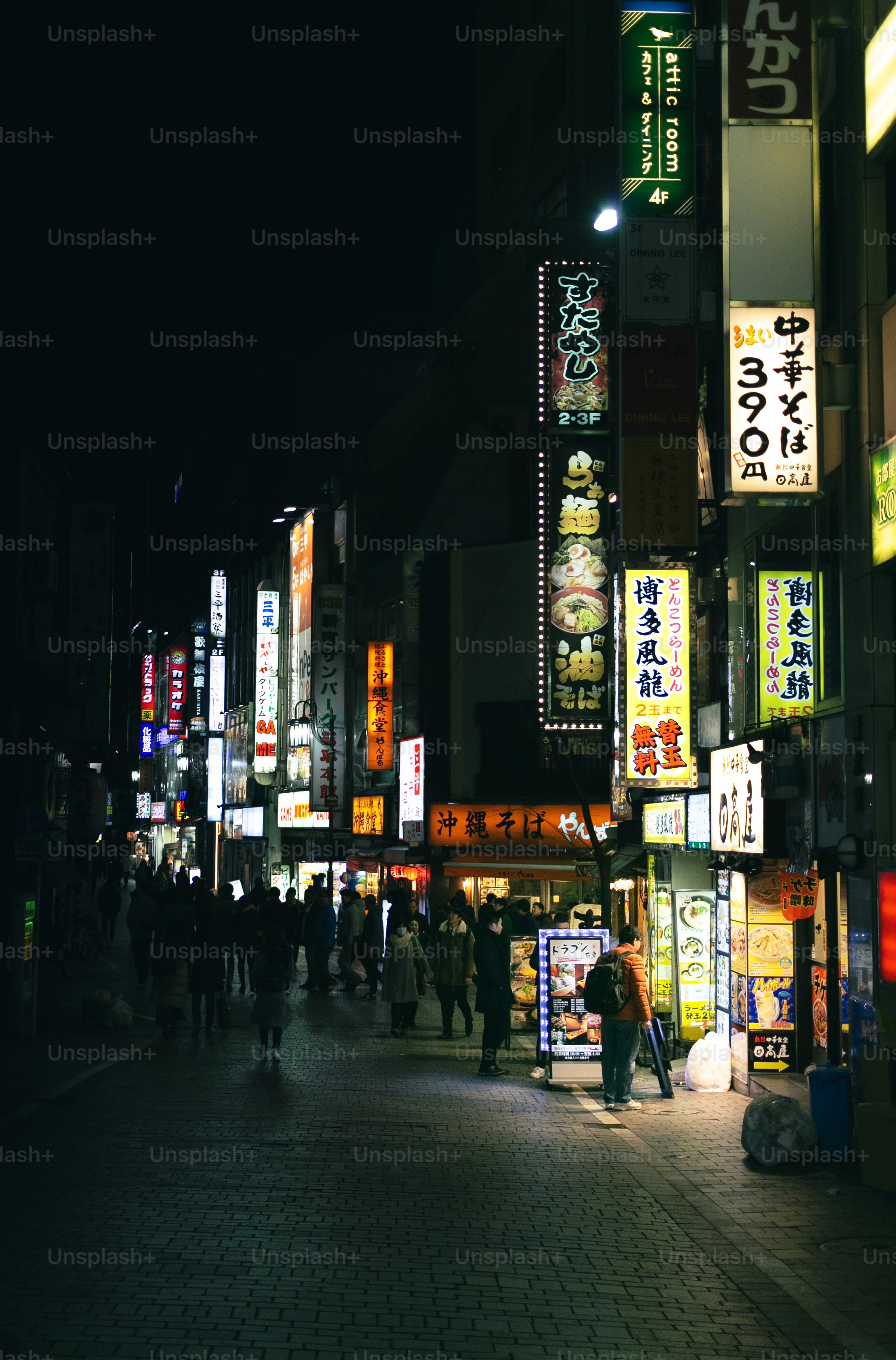 A group of people walking down a street at night